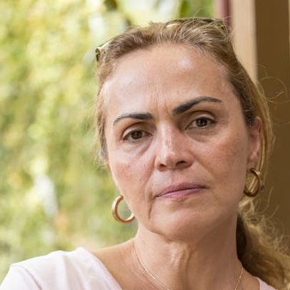 Concerned mature hispanic or middle eastern woman looking at the camera concerned